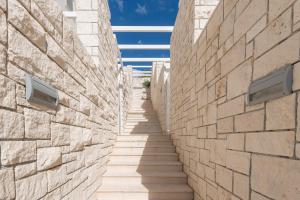 a hallway between two stone walls with stairs at Belado Residence Bol in Bol