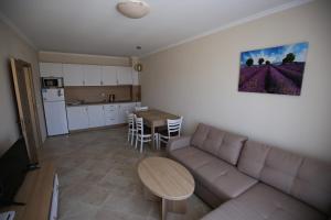 a living room with a couch and a table and a kitchen at Apartments in RIF 3 in Ravda