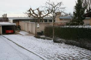 a snow covered driveway in front of a house at Bed & Kitchen Rugbjergvej in Stavtrup