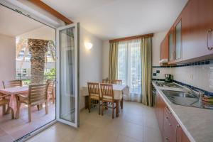 a kitchen with a table and a dining room at Apartments Punta in Veli Lošinj