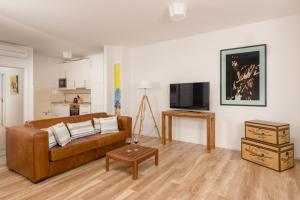 a living room with a brown couch and a tv at Belado Residence Bol in Bol