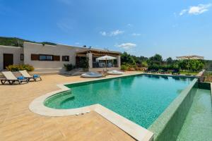 a swimming pool in front of a house at Villa Luna in Sant Joan de Labritja