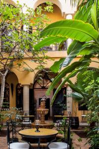 une cour avec des tables, des chaises et une fontaine dans l'établissement Riad Soleil D'orient, à El Jadida