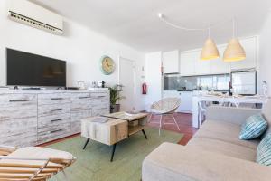 uma sala de estar com um sofá e uma mesa em Water Green House - Praia da Rocha em Portimão