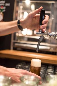 a person is pouring a beer into a glass at Hollmann Beletage Design & Boutique Hotel in Vienna