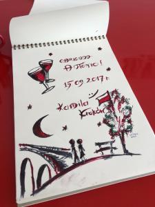 a notebook with a drawing of a couple sitting on a bench at Residencial Avenida Hostel in Tomar