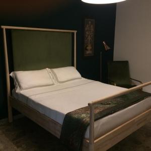 チェーリエ・メッサーピカにあるIl Mulinoのベッドルーム1室(緑のヘッドボード付きのベッド1台付)