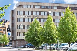 ein Gebäude mit Bäumen davor in der Unterkunft First Hotel Grand Falun in Falun