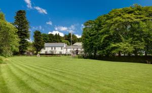 a large grassy field in front of a white house at Two Bridges Hotel in Two Bridges