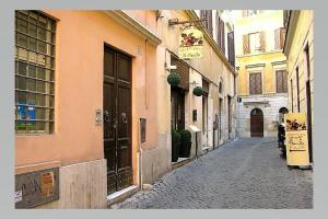 an alley with buildings and a person walking down a street at Vaccarella Pantheon in Rome