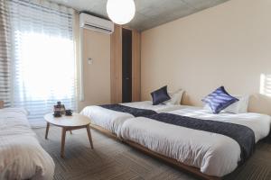a hotel room with two beds and a table at Naganoya in Kyoto