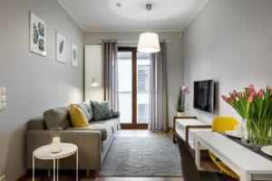 una sala de estar con un sofá y una mesa en UNIC Apartments Dominikańska, en Poznan