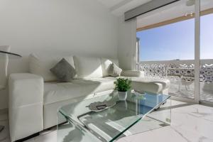 uma sala de estar com um sofá branco e uma mesa de vidro em Playa Honda 1A008 em Playa de las Americas