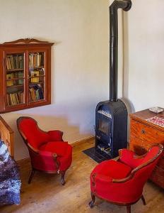 a living room with two chairs and a stove at Casa Arthur Richis in Richişu