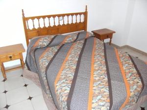レスカラにあるCasa la Florのベッドルーム1室(ベッド1台、木製テーブル2台付)