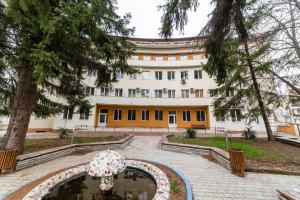 a building with an umbrella in a courtyard at Семеен хотел Пауталия in Kyustendil