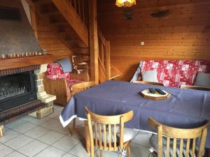 comedor con mesa y chimenea en Les Bruyeres wi fi, en La Bresse