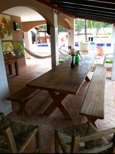 a large wooden table in a patio with two benches at Roteiro de charme in Paranoá