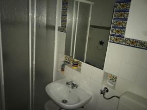 a bathroom with a white sink and a mirror at T0 Pedras D'el Rei in Tavira