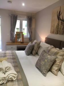 a bedroom with a large white bed with pillows at De Courceys Manor Suites & Cottages in Cardiff