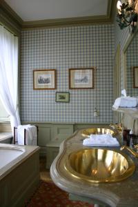 y baño con lavabo de oro y bañera. en Chateau De Pont-Rilly, en Négreville