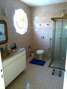 a bathroom with a shower and a sink and a toilet at Roteiro de charme in Paranoá