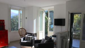 モルトラージオにあるCharming Villa with Lake view in Moltrasioのリビングルーム(椅子、テレビ、窓付)