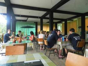 eine Gruppe von Personen, die in einem Restaurant an Tischen sitzen in der Unterkunft Birds Paradise Hotel in Kudawe