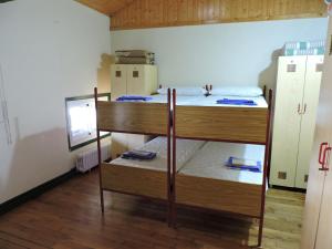 a room with two bunk beds and a refrigerator at Matxinbeltzenea in Lesaka