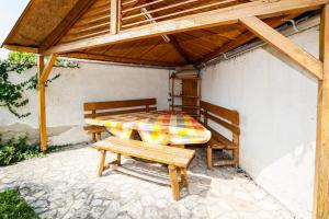 a patio with a bed and benches under a roof at Burg Vendégház in Eger