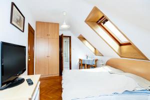 a bedroom with a bed with a tv and a window at Burg Vendégház in Eger