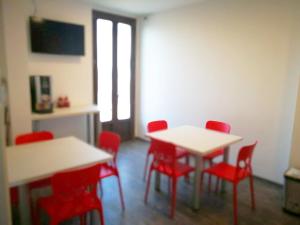 a room with red chairs and tables in a room at Residenza Borgazzi in Monza