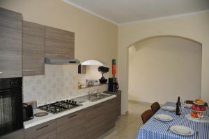 uma cozinha com um lavatório e um fogão forno superior em Doms Apartment em Tarxien