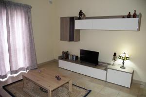 a living room with a tv and a coffee table at Doms Apartment in Tarxien