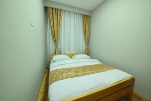 a bedroom with a bed with white sheets and pillows at Apartmani Milosevic in Bijeljina