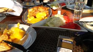 a wooden table with plates of food on it at Vikend kuća Careva Ćuprija-apartman in Olovo