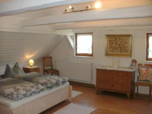a bedroom with a bed and a desk and two chairs at Gasthof Bischofsmühle in Helmbrechts