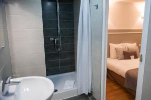 ein Bad mit einer Dusche, einem WC und einem Waschbecken in der Unterkunft Hôtel Le Stanislas in Nancy