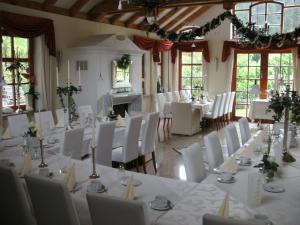 uma sala de jantar com mesas brancas e cadeiras brancas em Gasthof Bischofsmühle em Helmbrechts