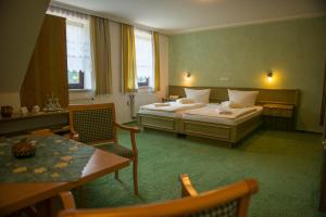 a hotel room with two beds and a table and chairs at Flair-Waldhotel Mellestollen in Saalfeld +78 photos