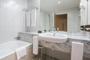 a bathroom with a sink and a bathtub at Hotel de Guimaraes in Guimarães