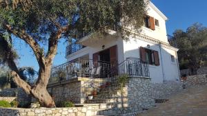 a white house with stairs and a tree at Villa Danae in Gaios