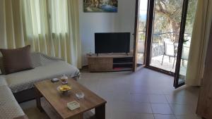 a living room with a couch and a tv and a table at Villa Danae in Gaios
