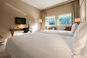 a hotel room with two beds and a television at Hotel de Guimaraes in Guimarães