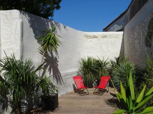 dos sillas rojas sentadas en un patio con plantas en Appartement Bastingage, en Saint-Martin-de-Ré 5 fotos más