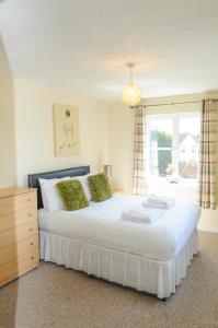 a bedroom with a large white bed with a window at Orchard Gate Apartments from Your Stay Bristol in Bristol