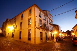 un gran edificio blanco en una calle por la noche en Hotel Altaïr en Santiago de Compostela
