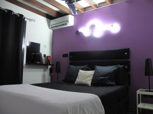 - une chambre dotée d'un lit avec un mur violet dans l'établissement Vert Lagon, à La Saline les Bains