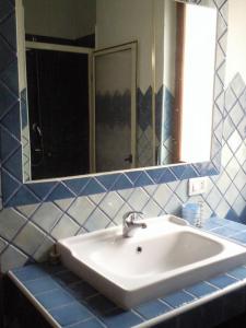 un bagno con un lavandino bianco e uno specchio di appartamento Oleandro a Cala Gonone