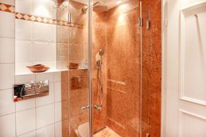 a shower with a glass door in a bathroom at Heefwai 2 W3 in Morsum